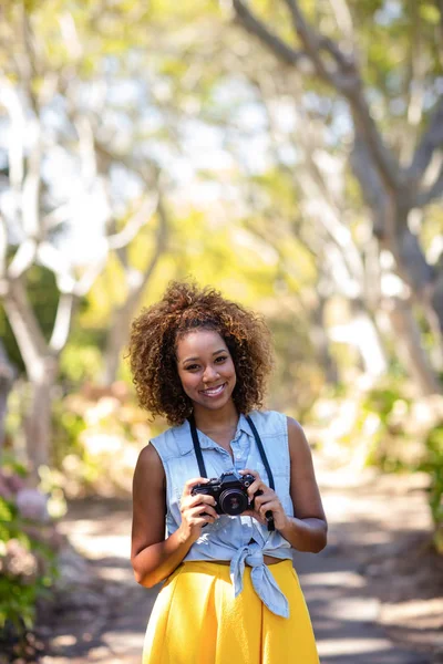 Mujer de pie con cámara digital — Foto de Stock