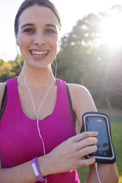 Vrouwelijke jogger luisteren naar muziek op telefoon — Stockfoto