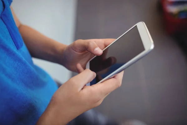 Schoolboy using mobile phone in corridor — Stock Photo, Image