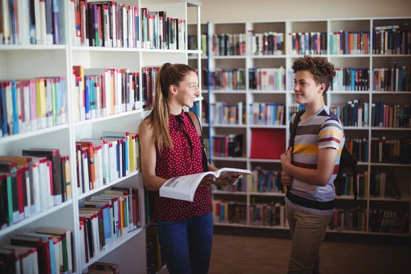 Klasskamrater som interagerar med varandra i biblioteket — Stockfoto