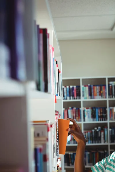 Μαθητής επιλέγοντας βιβλίο στη βιβλιοθήκη — Φωτογραφία Αρχείου