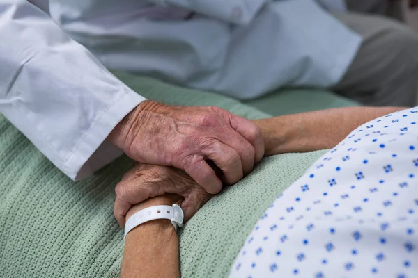 Doctor consoling senior patient in hospital — Stock Photo, Image