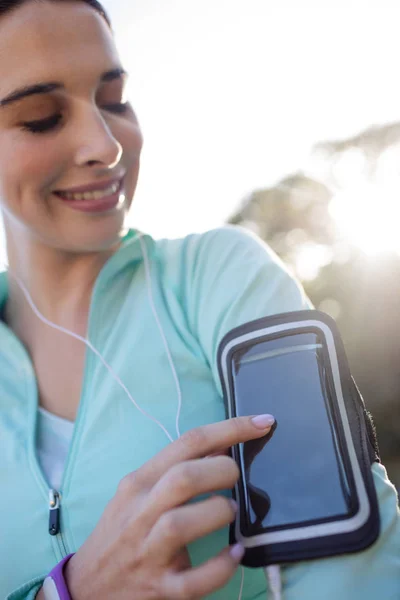 Ženské jogger posloucháte hudbu na telefonu — Stock fotografie