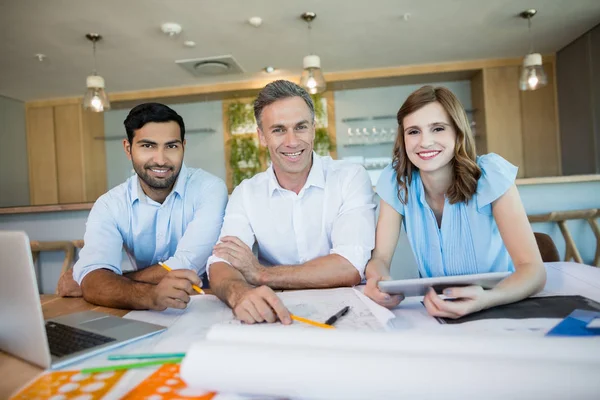 Lächelnde Architekten sitzen zusammen — Stockfoto