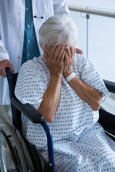 Médecin poussant le patient âgé en fauteuil roulant — Photo