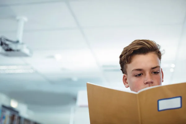 Schooljongen lezing boek in bibliotheek — Stockfoto