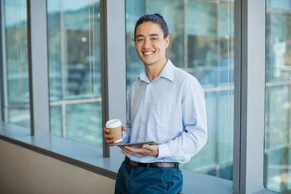 Ejecutivo de negocios usando la tableta mientras toma café — Foto de Stock