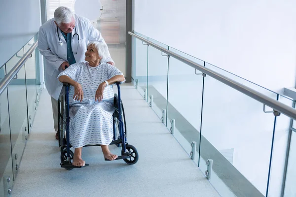 Arzt hält Seniorin im Rollstuhl — Stockfoto