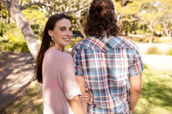 Ett par håller varandra i handen i parken — Stockfoto