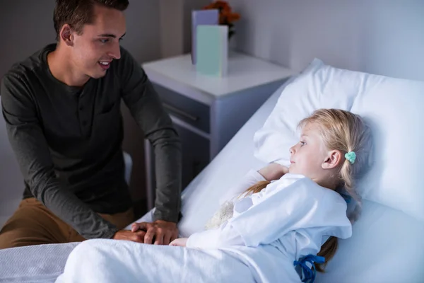 Pai ao lado de sua filha deitada na cama do hospital — Fotografia de Stock