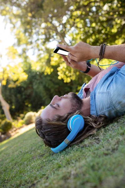 Man listening to music and using phone — Stock Photo, Image
