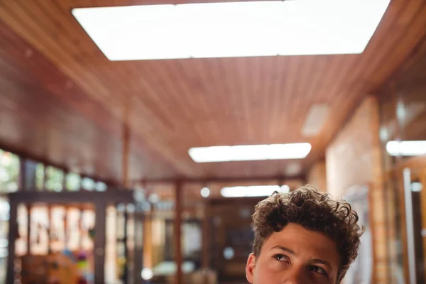 Ragazzo premuroso che guarda in su nel corridoio — Foto Stock