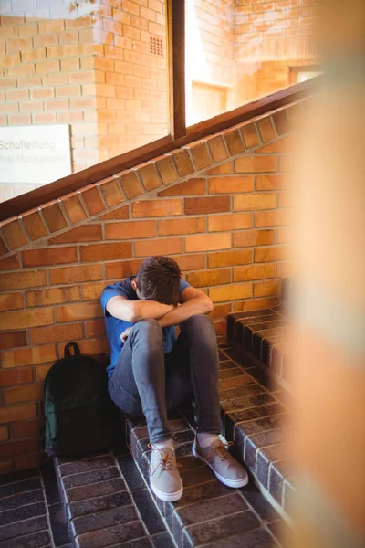 Школяр тримає планшет і книгу біля сходів — стокове фото