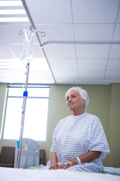 Worried senior patient sitting on bed — Stock Photo, Image