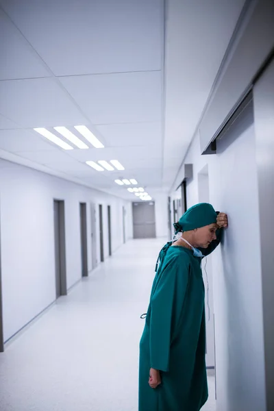 Tensed female surgeon leaning on wall — Stock Photo, Image