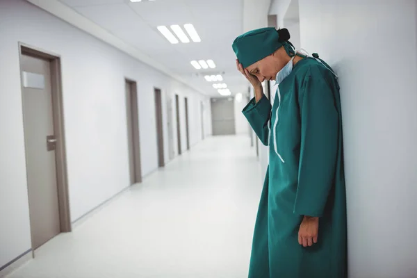 Tensed female surgeon standing in corridor — Stock Photo, Image