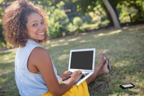 Nő ül a parkban, és használ laptop — Stock Fotó