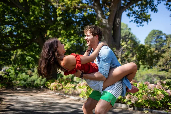 Man carrying woman in park — Stock Photo, Image