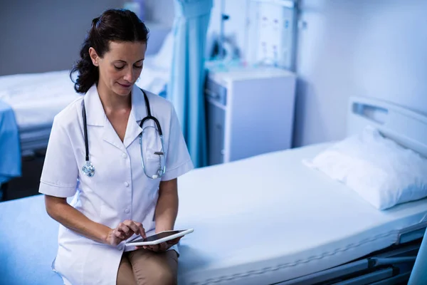 Médico femenino usando tableta en la sala —  Fotos de Stock