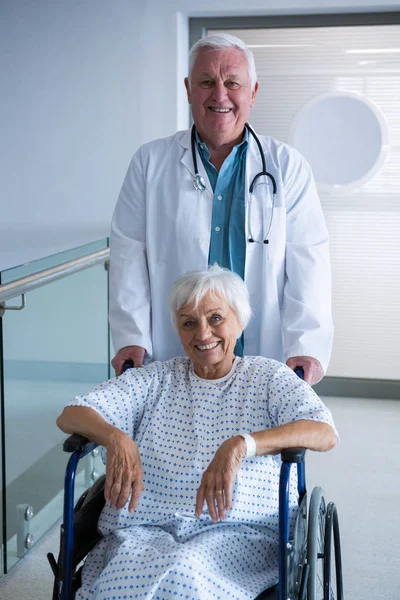 Medico titolare di un paziente anziano sulla sedia a rotelle — Foto Stock