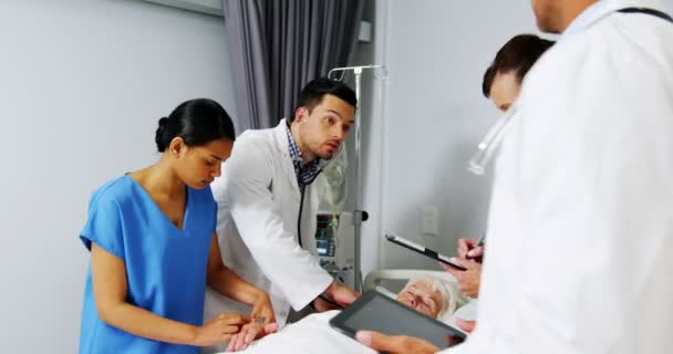 Lekarze badając starszy pacjenta w oddziale — Wideo stockowe