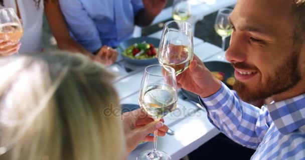 Vrienden voor het roosteren van glazen wijn op restaurant — Stockvideo