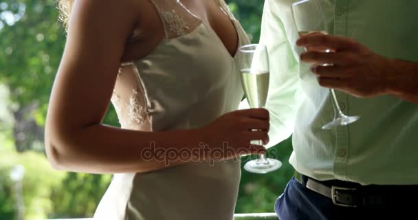 Casal olhando cara a cara e segurando flautas de champanhe no restaurante — Vídeo de Stock