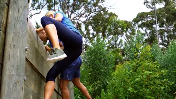 Пара спускається вниз по дерев'яній стіні — стокове відео