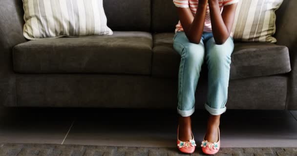 Upprörd flicka sitter på soffan i korridoren — Stockvideo