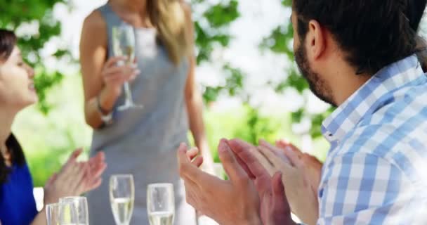 Freunde beim Mittagessen im Freien applaudieren für Frau — Stockvideo