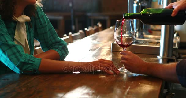 Μπάρμαν σερβίρει κόκκινο κρασί θηλυκό πελάτη στο μπαρ μετρητή — Αρχείο Βίντεο
