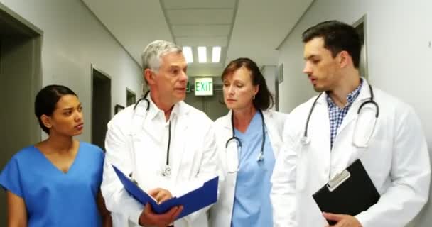Врачи и медсестра обсуждают медицинское заключение — стоковое видео