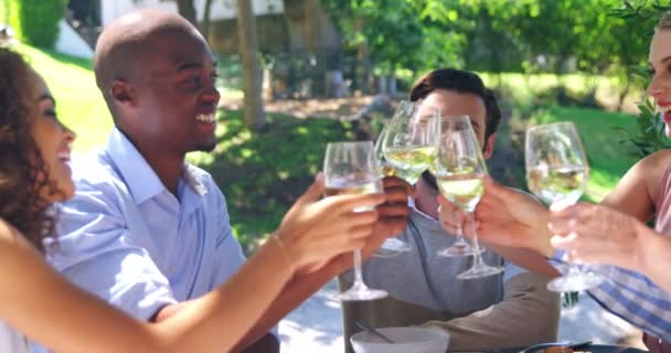 Przyjaciele opiekania kieliszków wina w restauracji — Wideo stockowe
