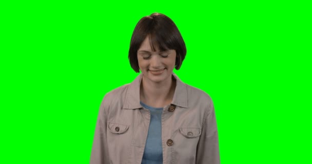 Женщина стоит на зеленом фоне — стоковое видео