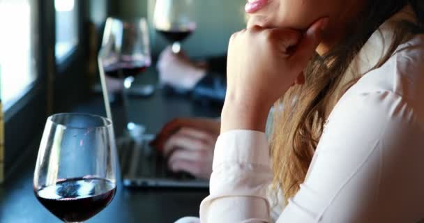 Schöne Frau mit einem Glas Wein im Restaurant — Stockvideo