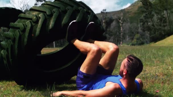 Man utför ben träning med däck — Stockvideo