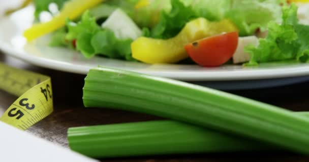 Salade de légumes dans une assiette avec ruban à mesurer — Video