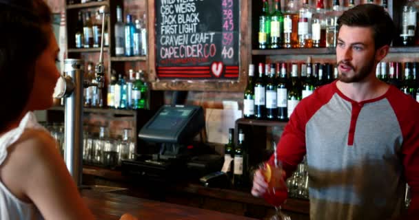 Barman interage com o cliente feminino enquanto serve coquetel — Vídeo de Stock