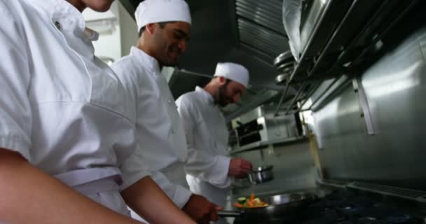 Команда кухарів рубає овочі та готує їжу — стокове відео