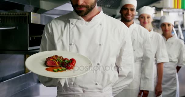 Equipe de chefs com um apresentando um prato — Vídeo de Stock