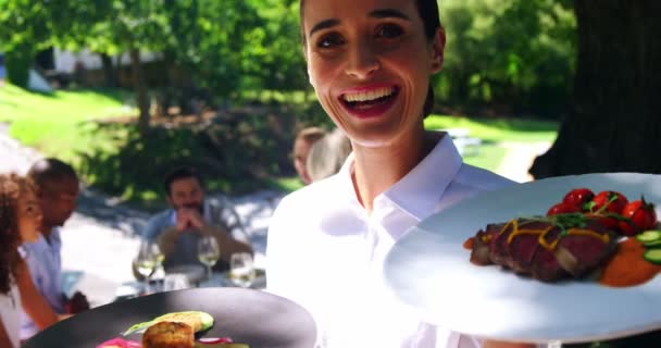 Usměvavá servírka s talířem jídla v restauraci — Stock video