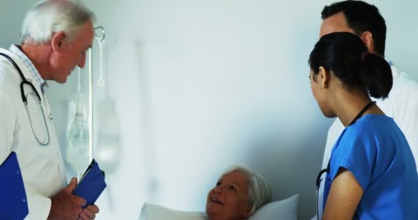 Group of doctors discussing report with old woman — Stock Video