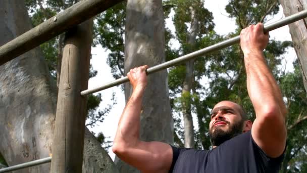 Hombre realizando pull-ups en el campamento de arranque — Vídeo de stock