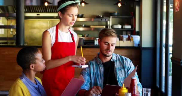 Официантка принимает заказы от клиентов — стоковое видео
