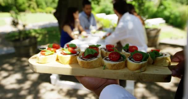 Garçom servindo aperitivos para casais — Vídeo de Stock