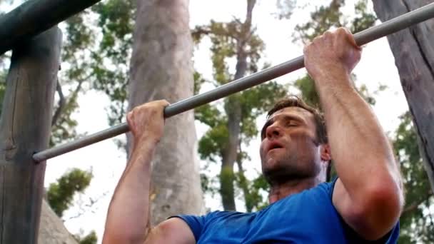 Hombre realizando pull-ups en el campamento de arranque — Vídeo de stock