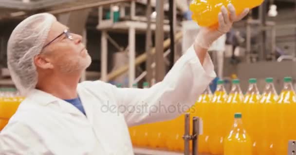 Trabajador examinando una botella en fábrica — Vídeo de stock