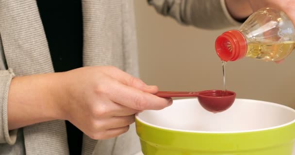 Mujer añadiendo ingredientes al bowl para hornear — Vídeo de stock