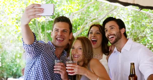 Group of friends taking selfie with mobile phone at bar counter — Stock Video