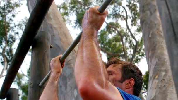 Hombre realizando pull-ups en el campamento de arranque — Vídeos de Stock